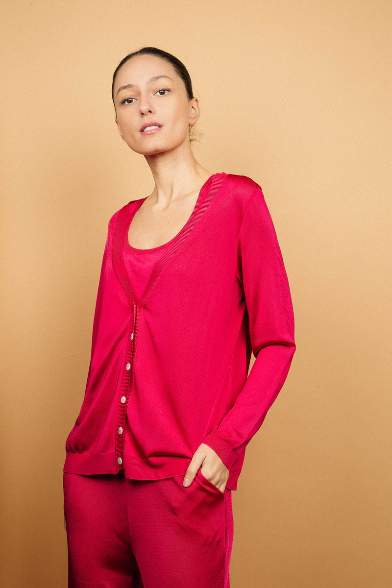 Cardigan rose fushia uni très lumineux en viscose, manches longues, encolure V, 6 boutons, finitions bords côtes. Coupe droite, fluide, porté en twin set avec le débardeur en viscose sans manches rose fushia et le pantalon fluide en viscose rose fushia uni.