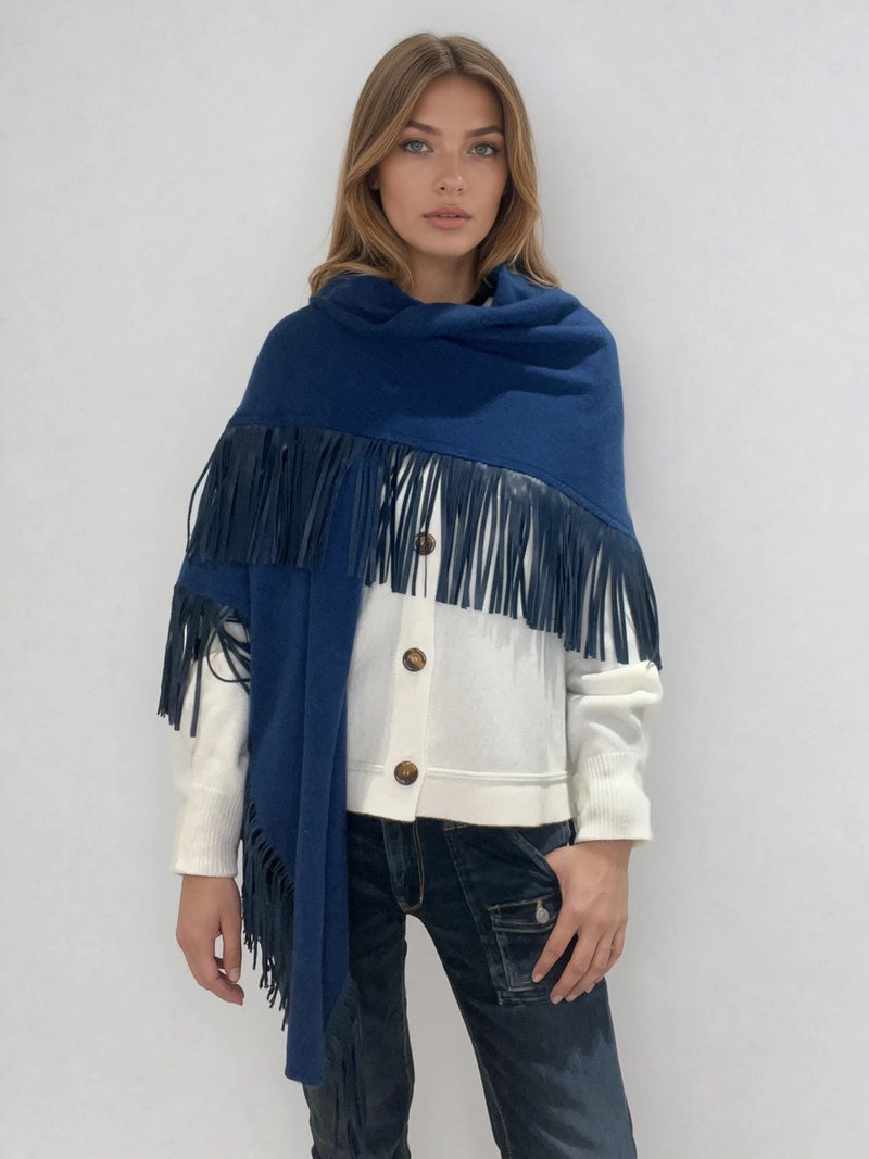 Châle triangulaire 170cm x 80cm coloris bleu Prusse 100% cachemire orné de franges en cuir d'agneau coloris bleu Prusse très souple. Le châle est porté sur la photo façon chèche. Vue face enveloppant l'épaule.