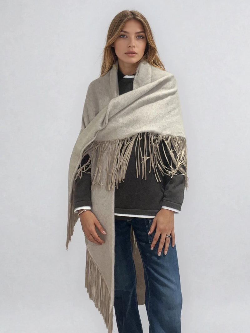 Châle triangulaire 170cm x 80cm coloris beige 100% cachemire orné de franges en cuir d'agneau coloris beige très souple. Vue face châle enveloppant l'épaule .