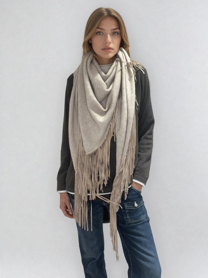 Châle triangulaire 170cm x 80cm coloris beige 100% cachemire orné de franges en cuir d'agneau coloris beige très souple. Le châle est porté sur la photo façon chèche. Vue face.
