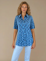 Chemise été femme, coloris bleu, manches courtes avec un imprimé strié.  La coupe avec un col est droite, les manches courtes arrivent au-dessus du coude. L'imprimé strié mélange des nuances de bleu et de blanc. Chemise en 100%viscose, lumineuse, fluide, très douce.
Vue face.