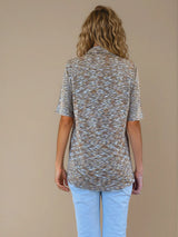 Chemise été femme, coloris kaki, manches courtes avec un imprimé strié.  La coupe avec un col est droite, les manches courtes arrivent au-dessus du coude. L'imprimé strié mélange des nuances de vert, d'orange et de beige. Chemise en 100%viscose, lumineuse, fluide, très douce. La longueur couvre largement le bas du dos.
Vue dos.