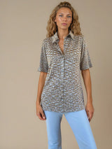 Chemise été femme, coloris kaki, manches courtes avec un imprimé strié.  La coupe avec un col est droite, les manches courtes arrivent au-dessus du coude. L'imprimé strié mélange des nuances de vert, d'orange et de beige. Chemise en 100%viscose, lumineuse, fluide, très douce.
Vue face.