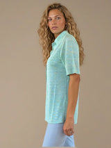 Chemise été femme, coloris vert clair, manches courtes avec un imprimé strié.  La coupe avec un col est droite, les manches courtes arrivent au-dessus du coude. L'imprimé strié mélange des nuances de vert et de jaune. Chemise en 100%viscose, lumineuse, fluide, très douce.
Vue profil.