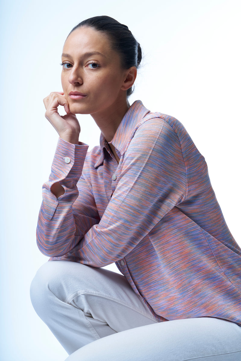 Chemise irisée manches longues en 100% viscose avec col et poignets. Aspect soie fluide et brillant de la viscose . Le coloris nuage est multicolore: mélange strié de bleu ciel et de rose. Coupe droite. 