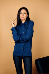 Chemise coloris denim, manches longues, coupe droite, 100% cachemire  avec un col large et des poignets. Vue face.