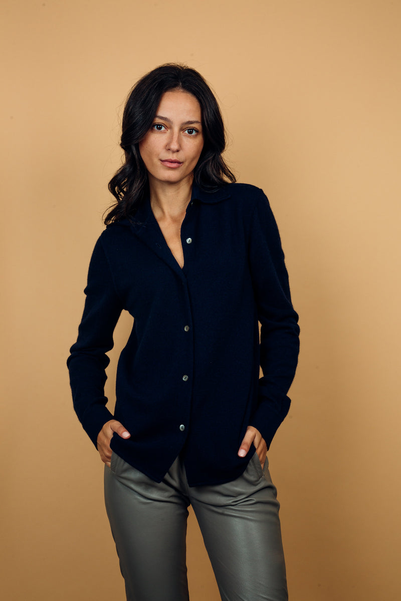 Chemise  coloris marine, manches longues, coupe droite, 100% cachemire  avec un col large et des poignets. Vue face.