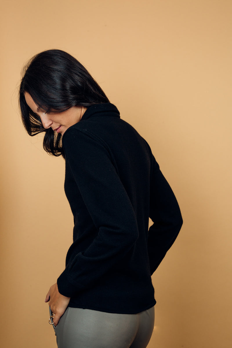 Chemise coloris noir, manches longues, coupe droite, 100% cachemire  avec un col large et des poignets. Vue  profil.