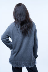 Chemise manches longues ou surchemise grise en cachemire, soie et mérinos. La chemise a 2 poches plaquées avec un rabat au niveau de la poitrine, est terminée dans le bas par une bande de franges en maille grise. Se porte également ouverte comme surchemise. Vue dos.