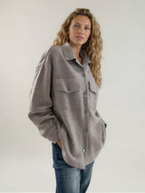 Surchemise coloris taupe fermée par 6 pressions. 2 poches plaquées au niveau de la poitrine et 2 fausses poches côtés.
Se porte comme une veste. Composition: 71%cachemire, 19% soie, 10% polyester, matière très douce.