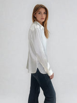 Chemise manches longues coloris écru en soie. Coupe légèrement cintrée avec 2 pinces dans le dos. Patte de boutonnage recouverte.  Vue profil.