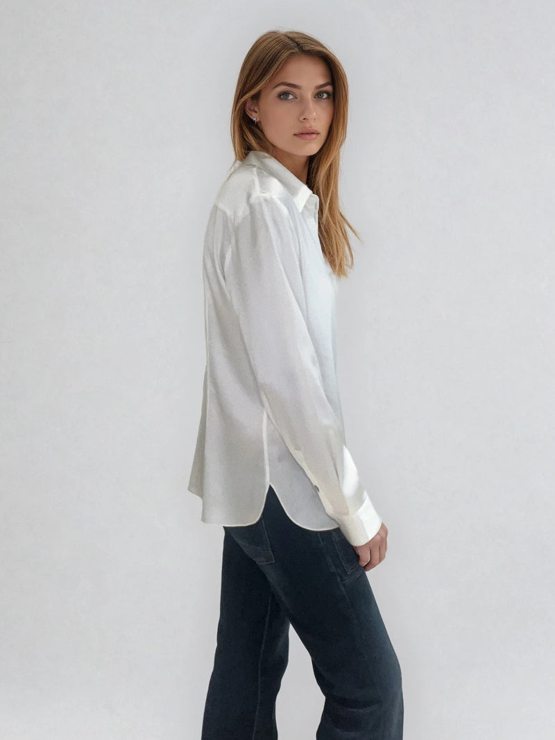 Chemise manches longues coloris écru en soie. Coupe légèrement cintrée avec 2 pinces dans le dos. Patte de boutonnage recouverte.  Vue profil.