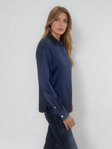 Chemise manches longues coloris marine en soie. Coupe légèrement cintrée avec 2 pinces dans le dos. Patte de boutonnage recouverte.  Vue profil.