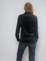 Chemise manches longues coloris noir en soie. Coupe légèrement cintrée avec 2 pinces dans le dos. Patte de boutonnage recouverte.  Vue dos.