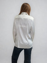 Chemise manches longues coloris écru en soie. Coupe légèrement cintrée avec 2 pinces dans le dos. Patte de boutonnage recouverte.  Vue dos.