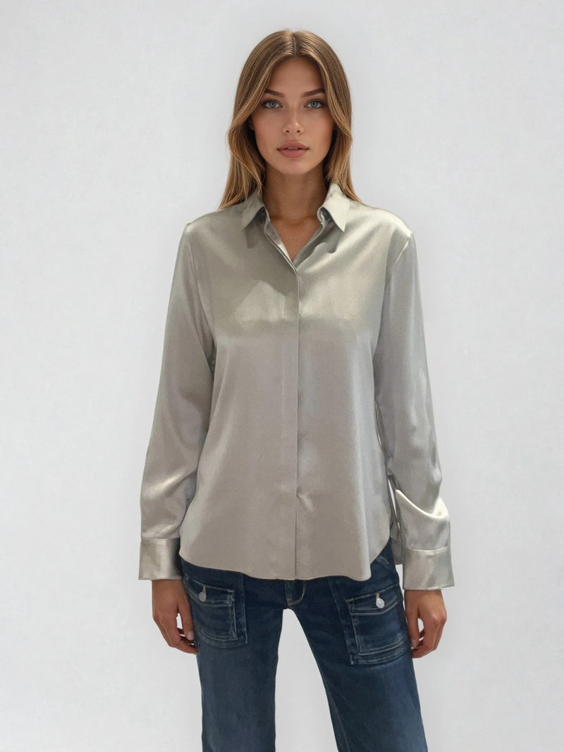 Chemise manches longues coloris taupe en soie. Coupe légèrement cintrée avec 2 pinces dans le dos. Patte de boutonnage recouverte.  Vue face.