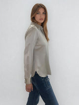 Chemise manches longues coloris taupe en soie. Coupe légèrement cintrée avec 2 pinces dans le dos. Patte de boutonnage recouverte.  Vue profil.