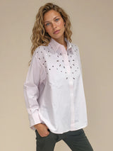 Chemise manches longues en 100% coton rayé rose et blanc. Petit col et forme trapèze avec des broderies ajourées au niveau du buste. Vue profil.