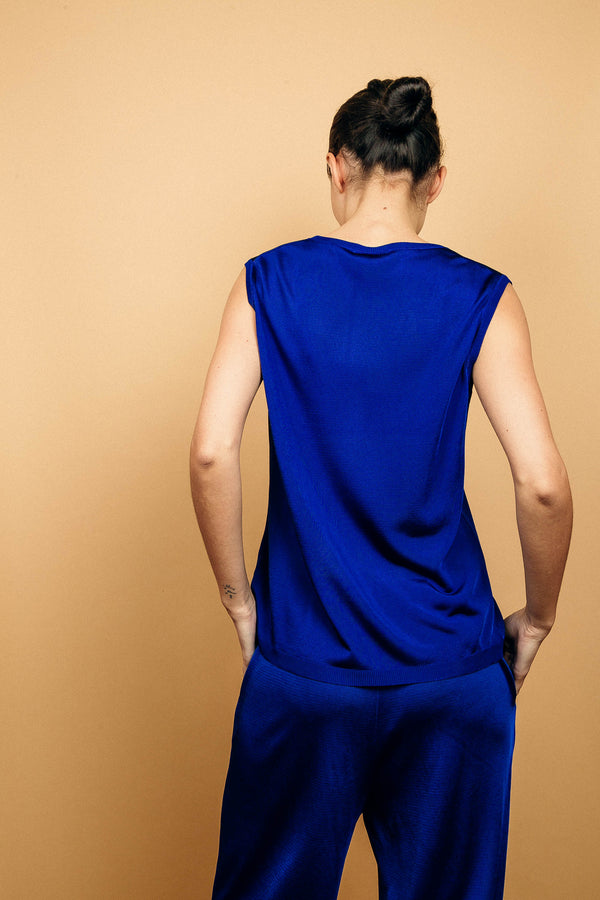Débardeur bleu uni sans manches, fluide, forme droite, le col est très arrondi, le cou est largement dégagé.
100%viscose, le coloris bleu est légèrement brillant. Le col, les emmanchures et le bas sont terminés par des côtes. Vue du dos.