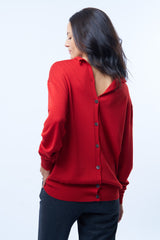 Gilet rouge en 100% mérinos qui se boutonne également dans le dos pour le porter en version pull. Col roulotté et asymétrique. Ouverture sur le poignet pour laisser passer le pouce. Vue dos.