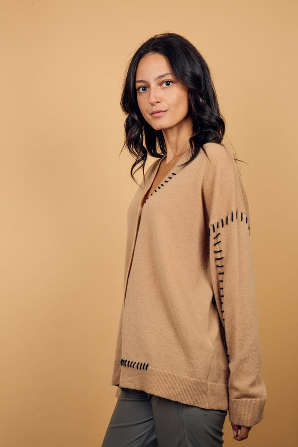 Gilet manches longues coloris camel avec une coupe droite. Les emmanchures sont basses, finitions côtes. Particularité de ce gilet: il est comme reprisé sur un côté du col, des coutures emmanchures, et une partie du bas avec un fil marine, effet rapiécé.
45%cachemire et 55% mérinos