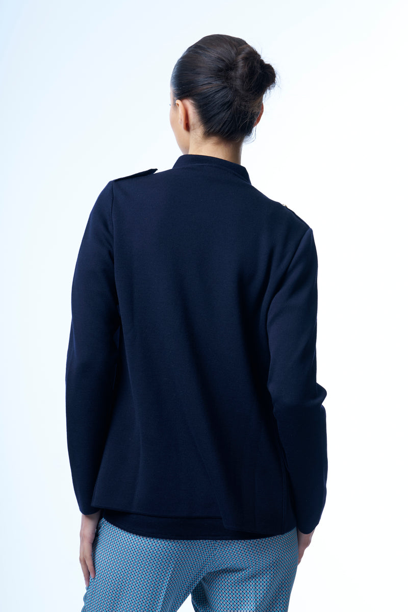 Gilet en 100% mérinos marine, manches longues. Il a des épaulettes ornées d'un bouton doré. Il peut se porter croisé avec 3 boutons dorés sur le côté gauche ou ouvert, le col est souple.
A associer avec une chemise en mérinos marine. Vue dos.