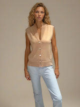 Gilet sans manches coloris biscuit, ton abricot. Le gilet reprend les codes d'un gilet d'homme 5 boutons avec en plus un double col V. Finitions côtes. 56% laine mérinos et 44% soie.
Vue face.