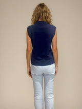 Gilet sans manches coloris marine, ton abricot. Le gilet reprend les codes d'un gilet d'homme 5 boutons avec en plus un double col V. Finitions côtes. 56% laine mérinos et 44% soie.
Vue dos.