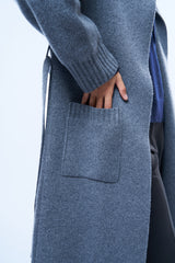Gilet long avec manges longues gris foncé avec ceinture attachée par 2 passants. Vue détail poche. Finitions côtes. Composition: 42% cachemire,8% soie et 50% laine mérinos.