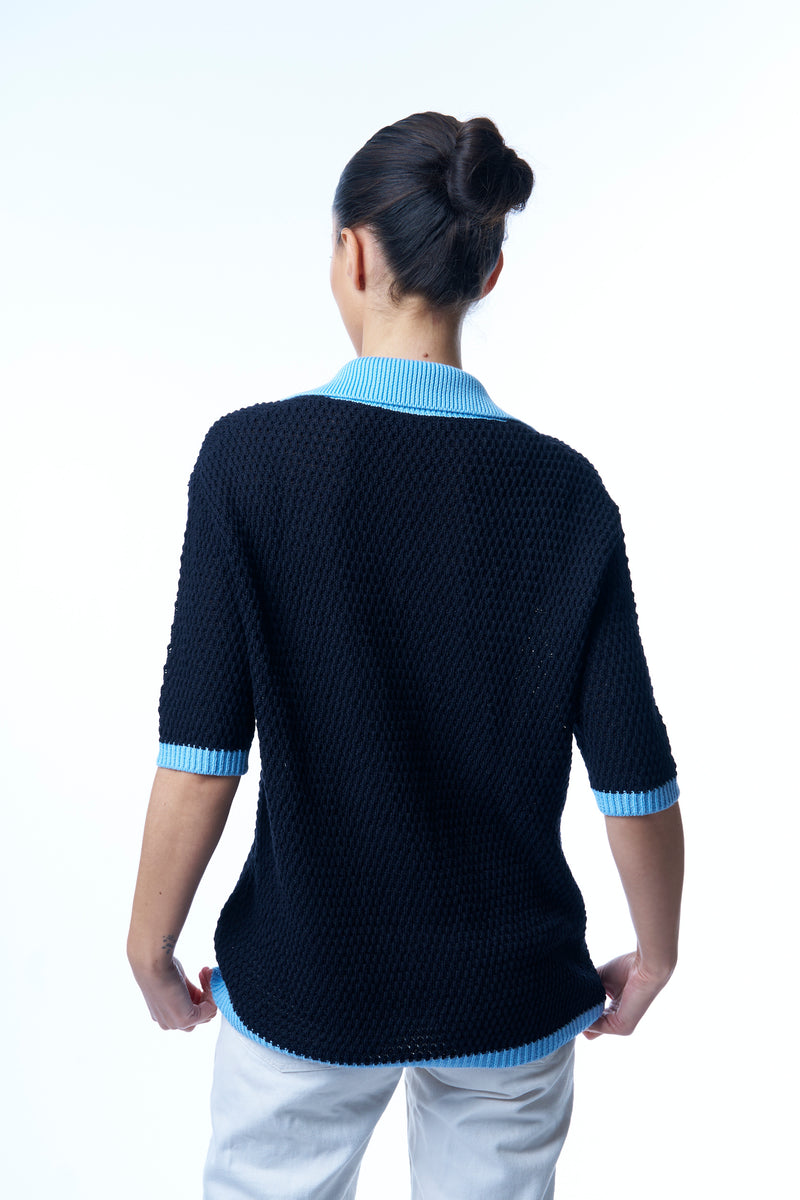 Gilet bicolore: le fond est bleu marine , l'encolure est bleu ciel, les finitions des manches et du gilet forment une bande de 2.5 cm bleu ciel. La maille est souple et ajourée. 85% coton et 15% cachemire, manches courtes couvrant bien les avant-bras. Vue dos.