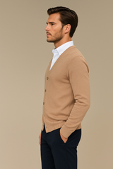 Gilet col V camel pour homme en cachemire, soie, mérinos. La coupe est droite, il est boutonné devant. Emmanchures droites, allure décontractée. Vue profil.