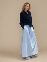 Jupe longue ciel en 100% coton, la coupe est ample et se termine par une finition ballon. Taille élastiquée avec 2 poches italiennes sur les côtés.
Vue profil