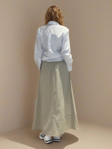 Jupe longue beige en 100% coton, la coupe est ample et se termine par une finition ballon. Taille élastiquée avec 2 poches italiennes sur les côtés.
Vue dos.