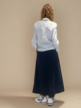 Jupe longue marine en 100% coton, la coupe est ample et se termine par une finition ballon. Taille élastiquée avec 2 poches italiennes sur les côtés.
Vue dos.
