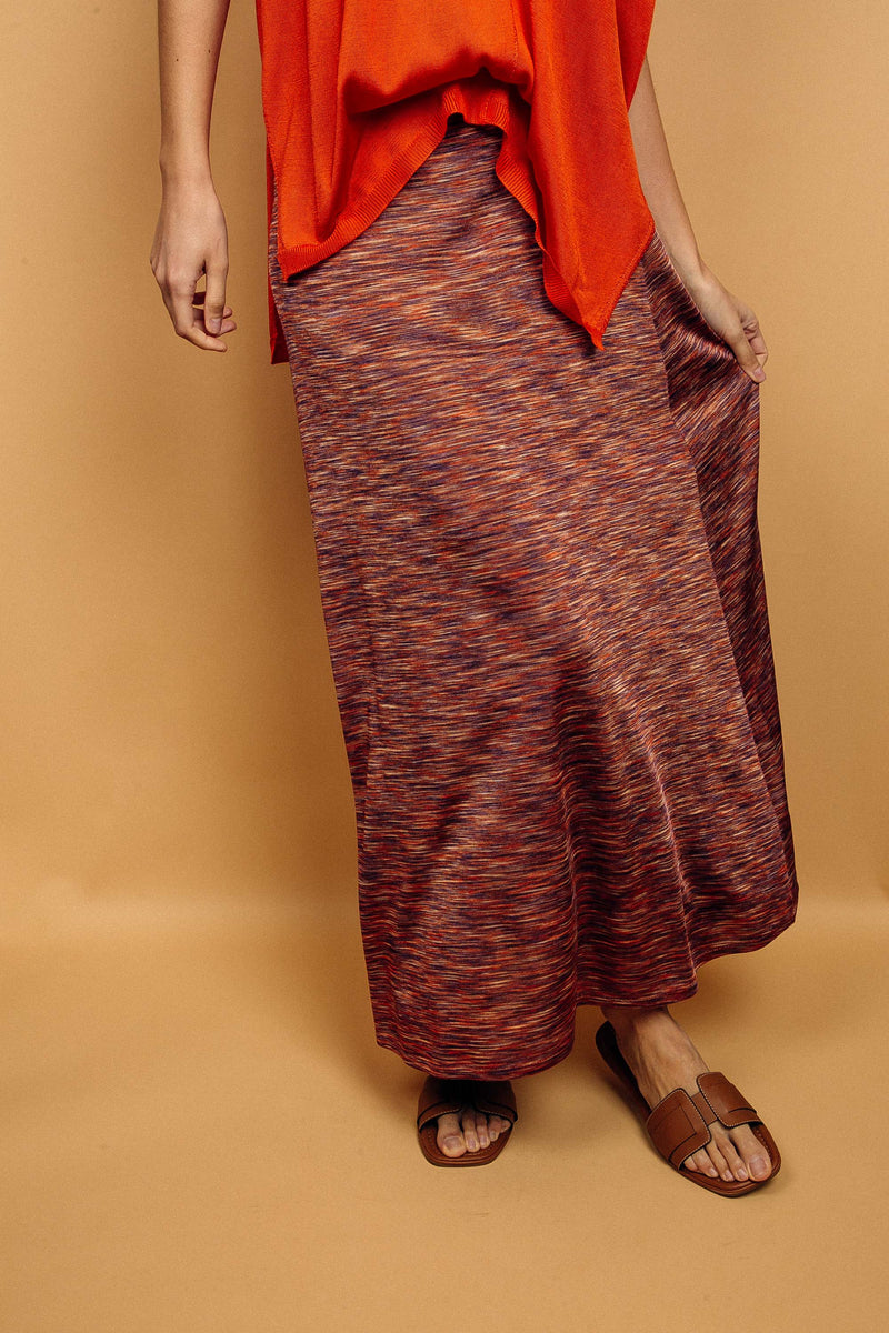 Jupe longue de 90 cm, doublée sur 40 cm, taille élastiquée, imprimé orange qui est un mélange d'orange, de brun, de beige, réunis dans un graphisme strié très lumineux. La jupe est légèrement évasée, elle est en 100% maille viscose ,très fluide.