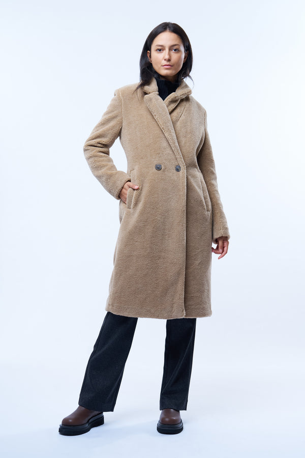 Manteau beige en fausse fourrure effet bouclé. 100% polyester. Coupe droite façon pardessus croisé, fermé par 2 boutons. Col tailleur, 2 poches cotés.