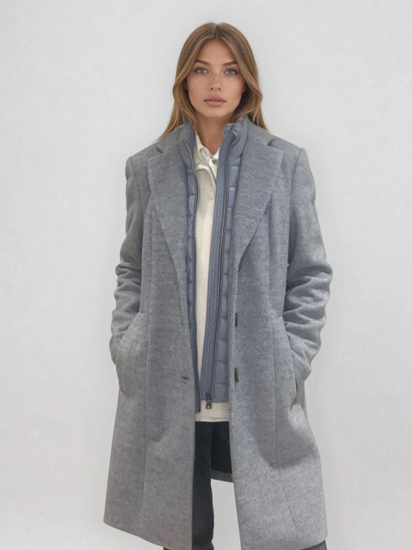 Manteau coupe droite style pardessus masculin coloris gris très clair fermé par 3 boutons. Manches montées, 2 poches. Un col façon doudoune se zippe sur le col tailleur.