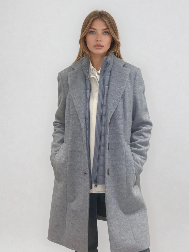 Manteau coupe droite style pardessus masculin coloris gris très clair fermé par 3 boutons. Manches montées, 2 poches. Un col façon doudoune se zippe sur le col tailleur.