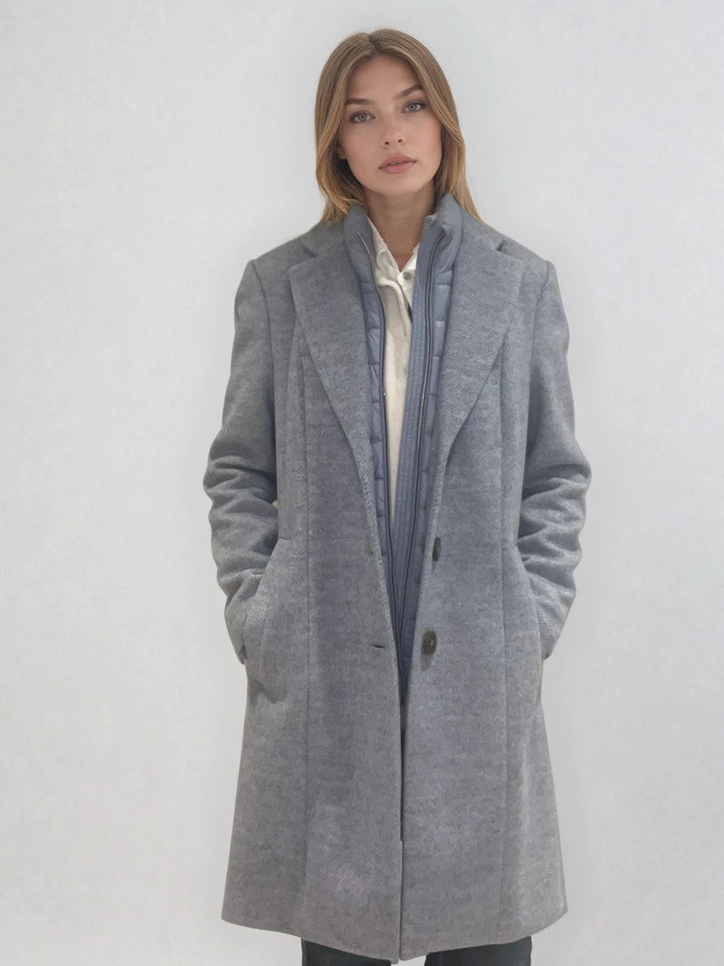 Manteau coupe droite style pardessus masculin coloris gris très clair fermé par 3 boutons. Manches montées, 2 poches. Un col façon doudoune se zippe sur le col tailleur.