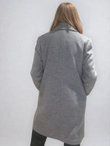 Manteau coupe droite style pardessus masculin coloris gris très clair fermé par 3 boutons. Manches montées, 2 poches. Un col façon doudoune se zippe sur le col tailleur.