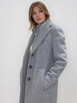 Manteau coupe droite style pardessus masculin coloris gris très clair fermé par 3 boutons. Manches montées, 2 poches. Un col façon doudoune se zippe sur le col tailleur.