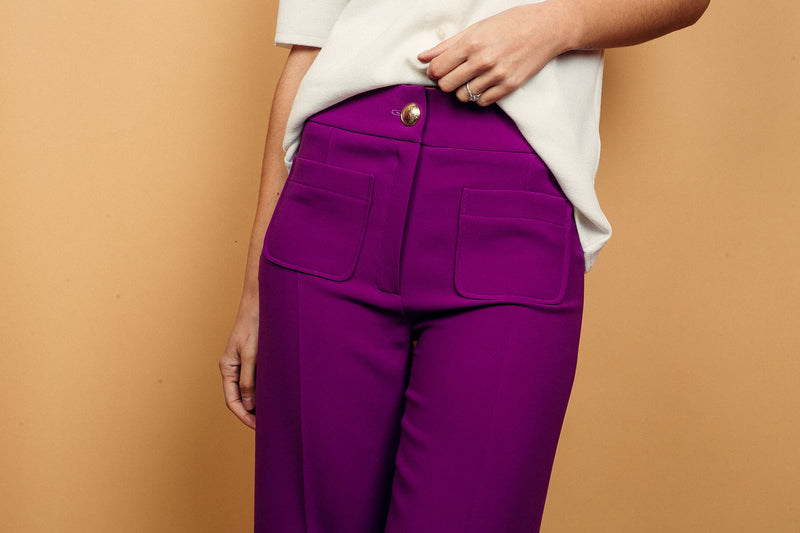 Pantalon BRIGITTE coloris aubergine, coupe large sur toute la jambe, 2 poches plaquées sur le devant. Taille placée avec bouton doré. Texture douce et fluide 95% viscose et 5% élasthanne.