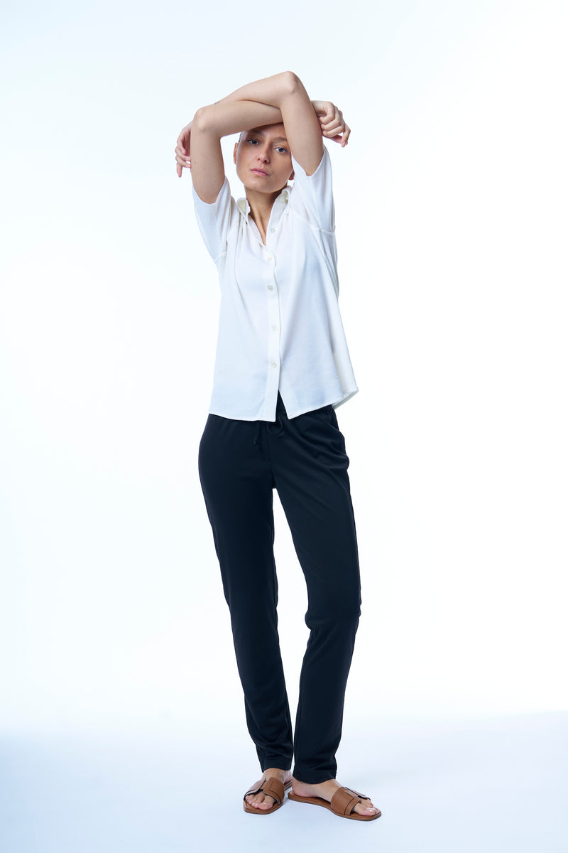 Pantalon coloris marine, coupe jogging avec une taille élastiquée et un cordon. Le pantalon est légèrement resserré dans le bas. Fluide, léger, jogging chic.