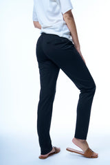 Pantalon coloris marine, coupe jogging avec une taille élastiquée et un cordon. Le pantalon est légèrement resserré dans le bas. 2 fausses poches passepoilées au dos. Fluide, léger, jogging chic.