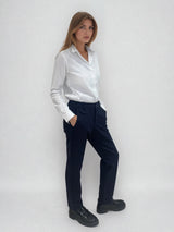 Pantalon marine de ville avec une forme droite. Poches italiennes et dos élastiqué. Détail de la patte rehaussée de fil lurex au niveau des passants. Vue profil.