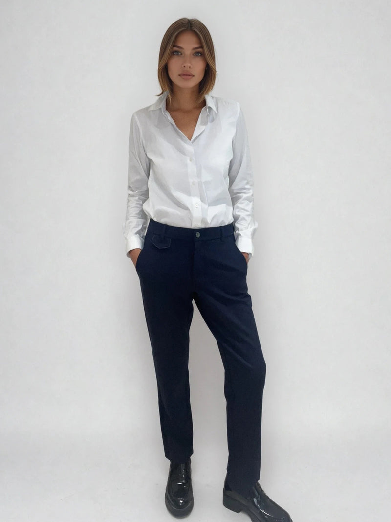 Pantalon marine de ville avec une forme droite. Poches italiennes et dos élastiqué. Détail de la patte rehaussée de fil lurex au niveau des passants. Vue face.