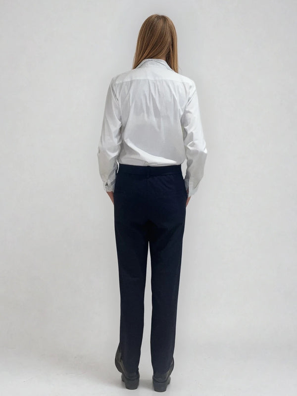 Pantalon marine de ville avec une forme droite. Poches italiennes et dos élastiqué. Détail de la patte rehaussée de fil lurex au niveau des passants. Vue dos.