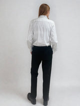 Pantalon noir de ville avec une forme droite. Poches italiennes et dos élastiqué. Détail de la patte rehaussée de fil lurex au niveau des passants. Vue dos.