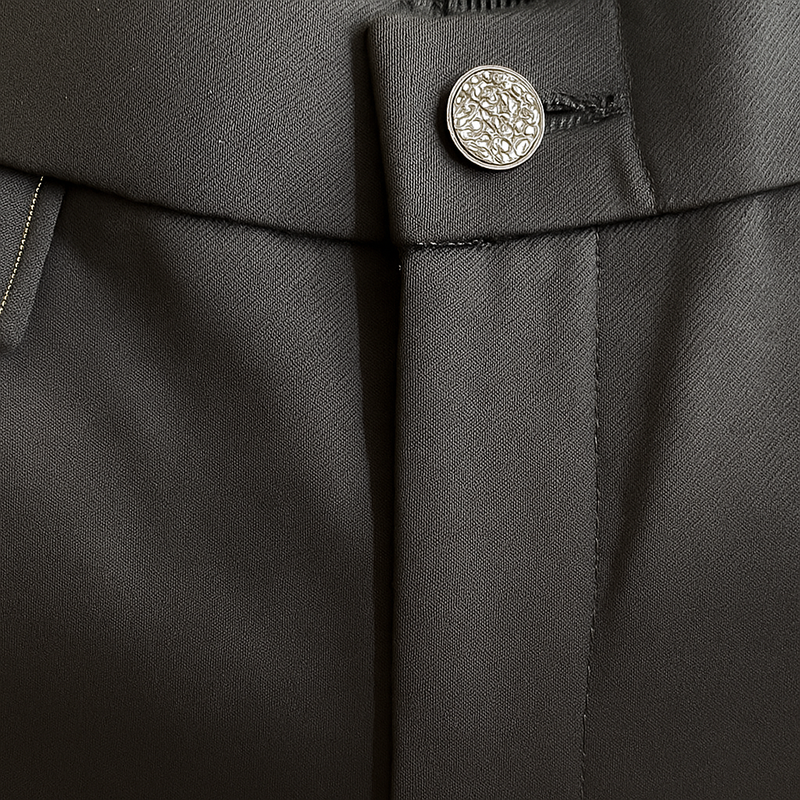 Pantalon noir de ville avec une forme droite. Poches italiennes et dos élastiqué. Détail du bouton.