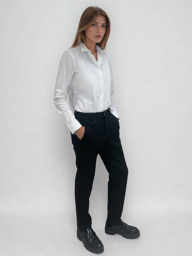 Pantalon noir de ville avec une forme droite. Poches italiennes et dos élastiqué. Détail de la patte rehaussée de fil lurex au niveau des passants. Vue profil.